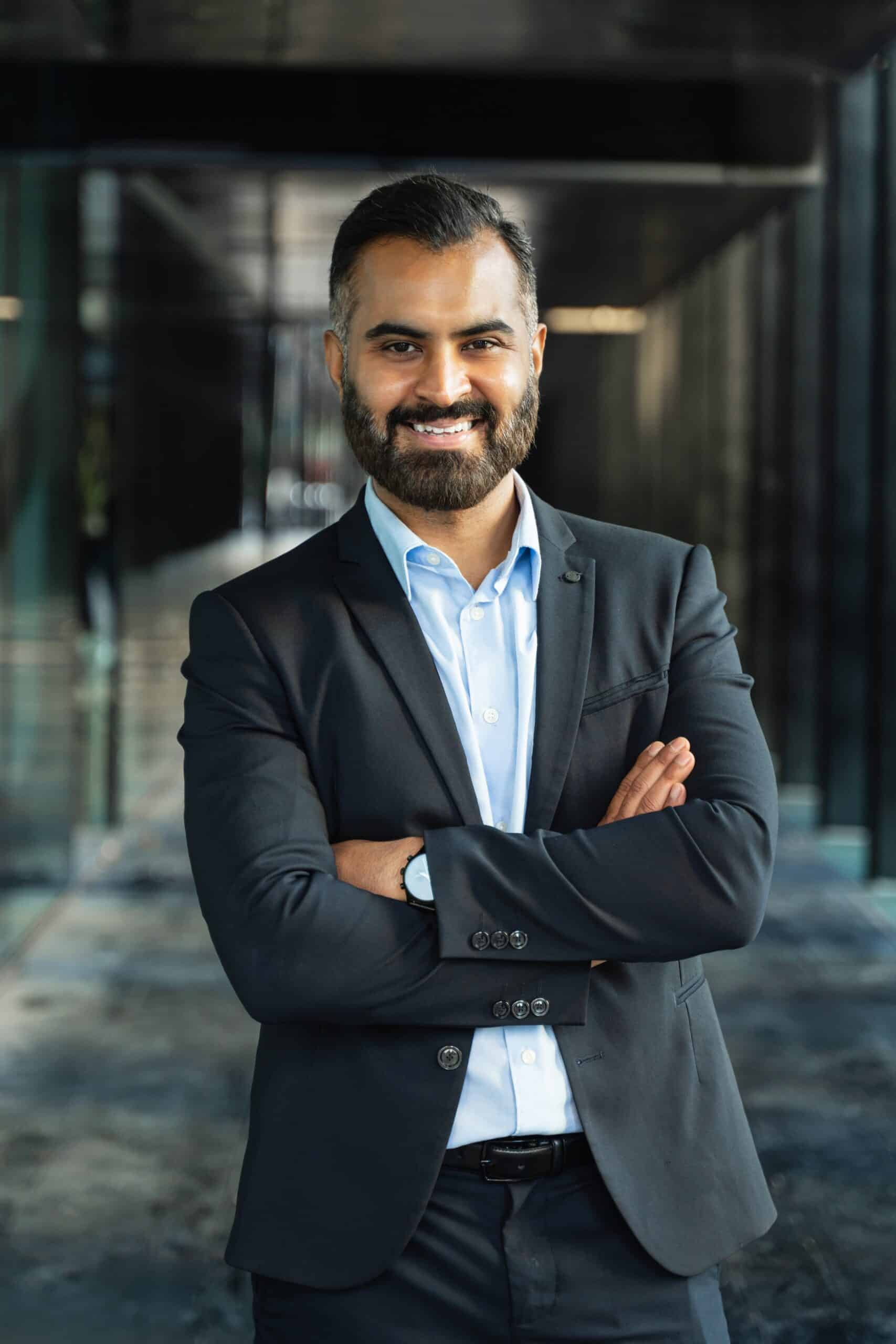 Confident,Indian,Business,Man,Standing,With,Crossed,Arms,,Smiling,In