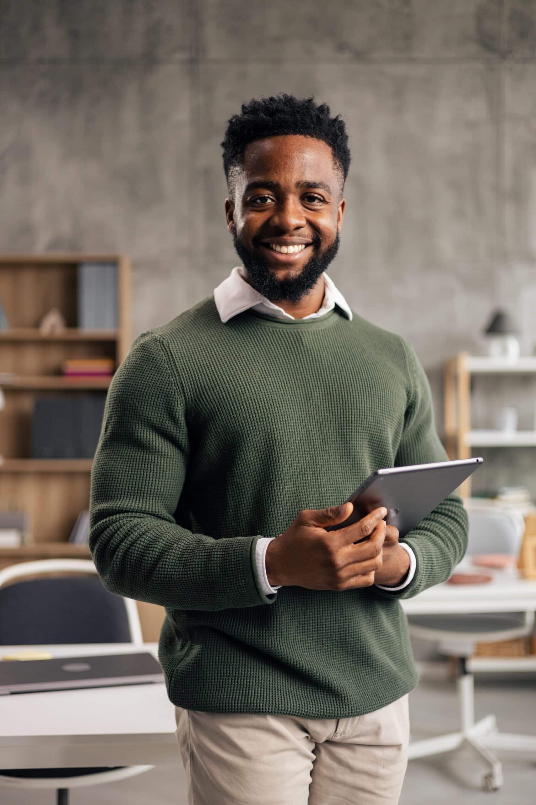Black,Man,Smiling,,Holding,A,Digital,Tablet,In,A,Modern